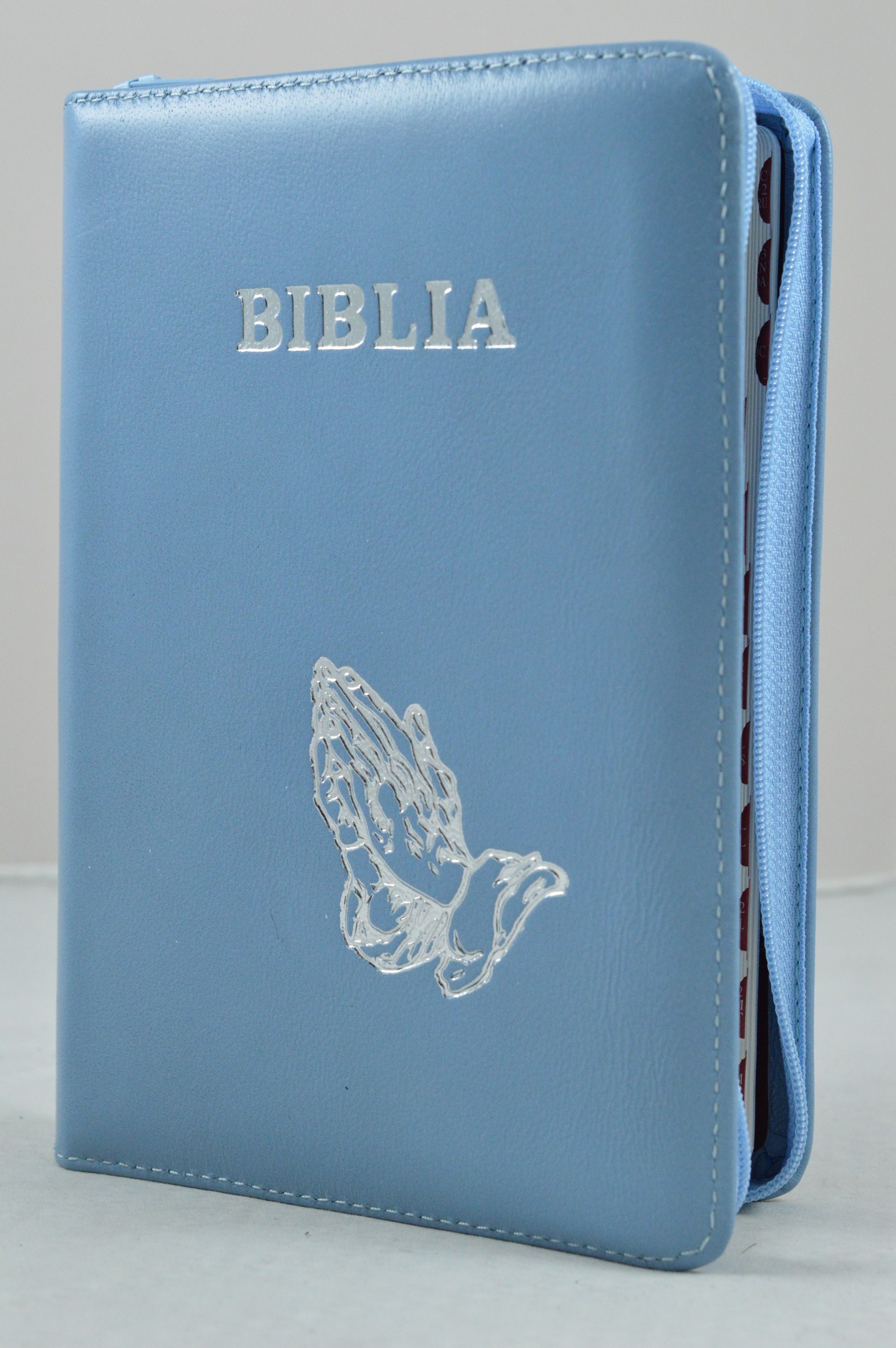 Biblie din piele, marime medie, albastru  deschis, simbol maini in ruga, fermoar, index, margini argintii, cuv. lui Isus cu rosu [SB 057 PFI]